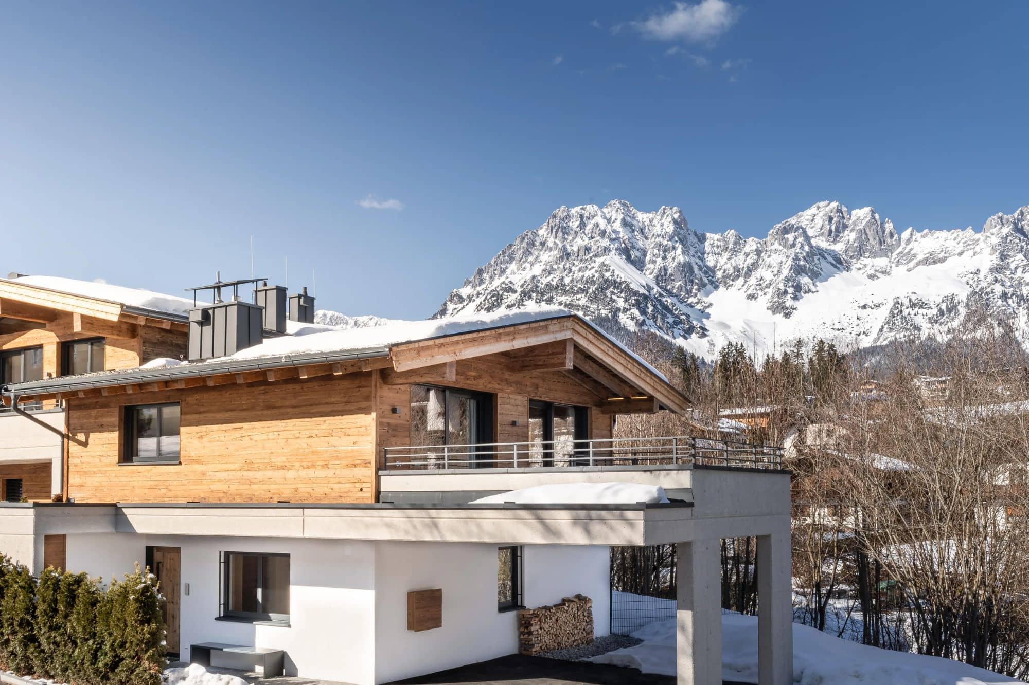 A snowy chalet surrounded by mountains.