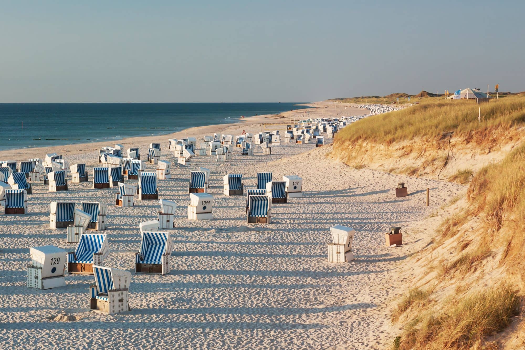Ein Strand mit lauter Strandkörben am Meer auf Sylt.