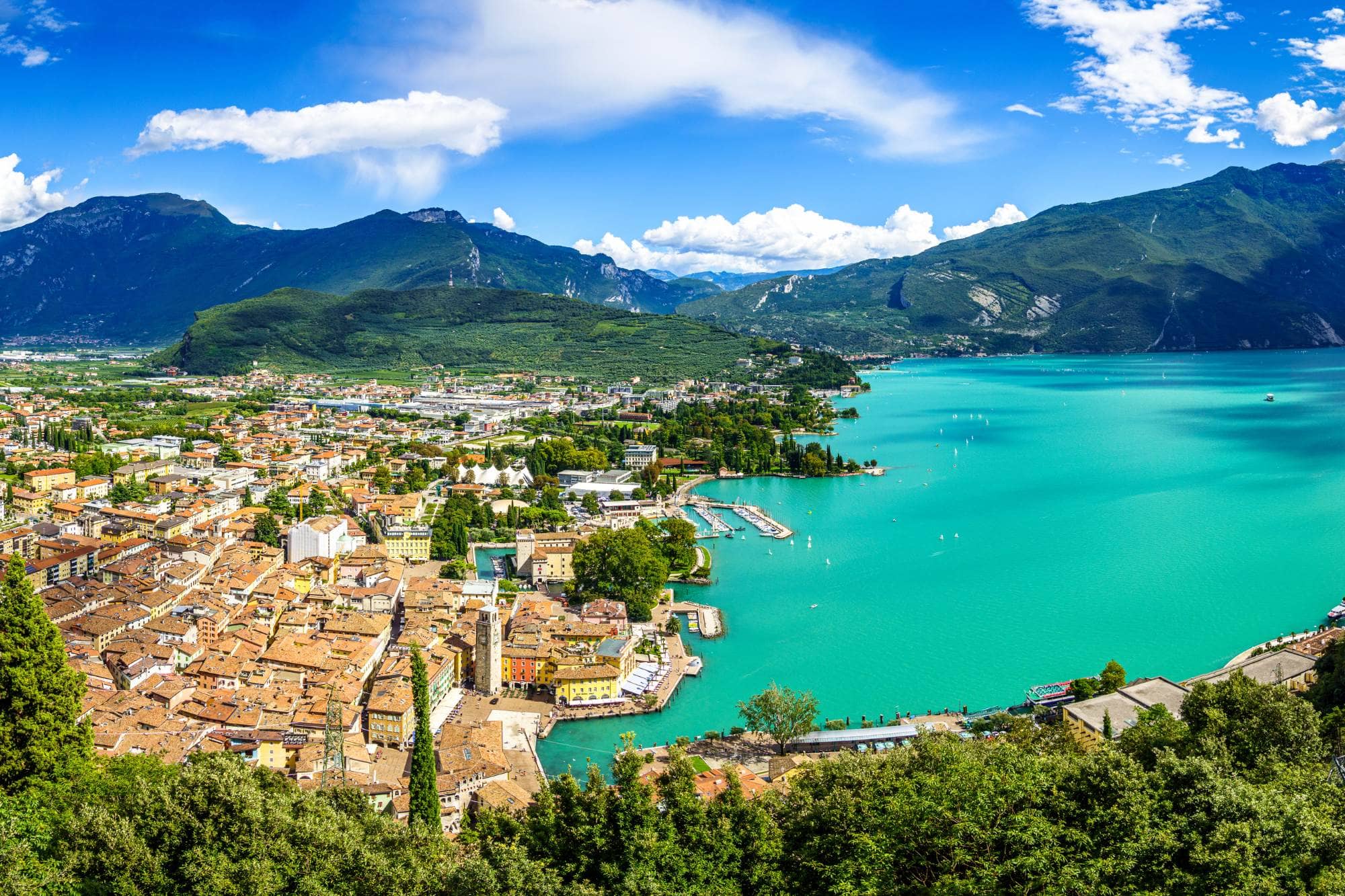 Eine italienische Stadt am Gardasee umgeben von Bergen.