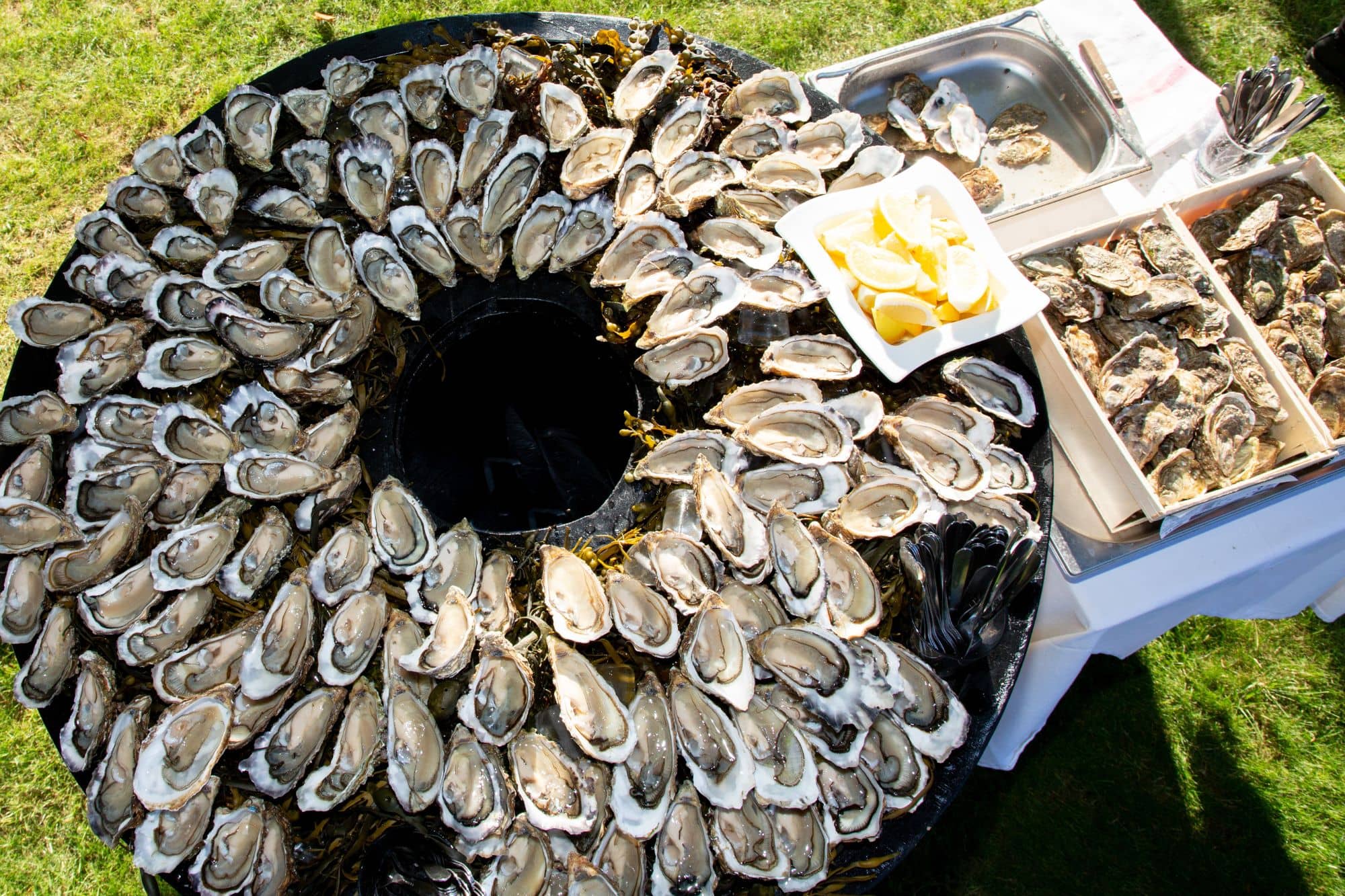 A platter with oysters and lemons.