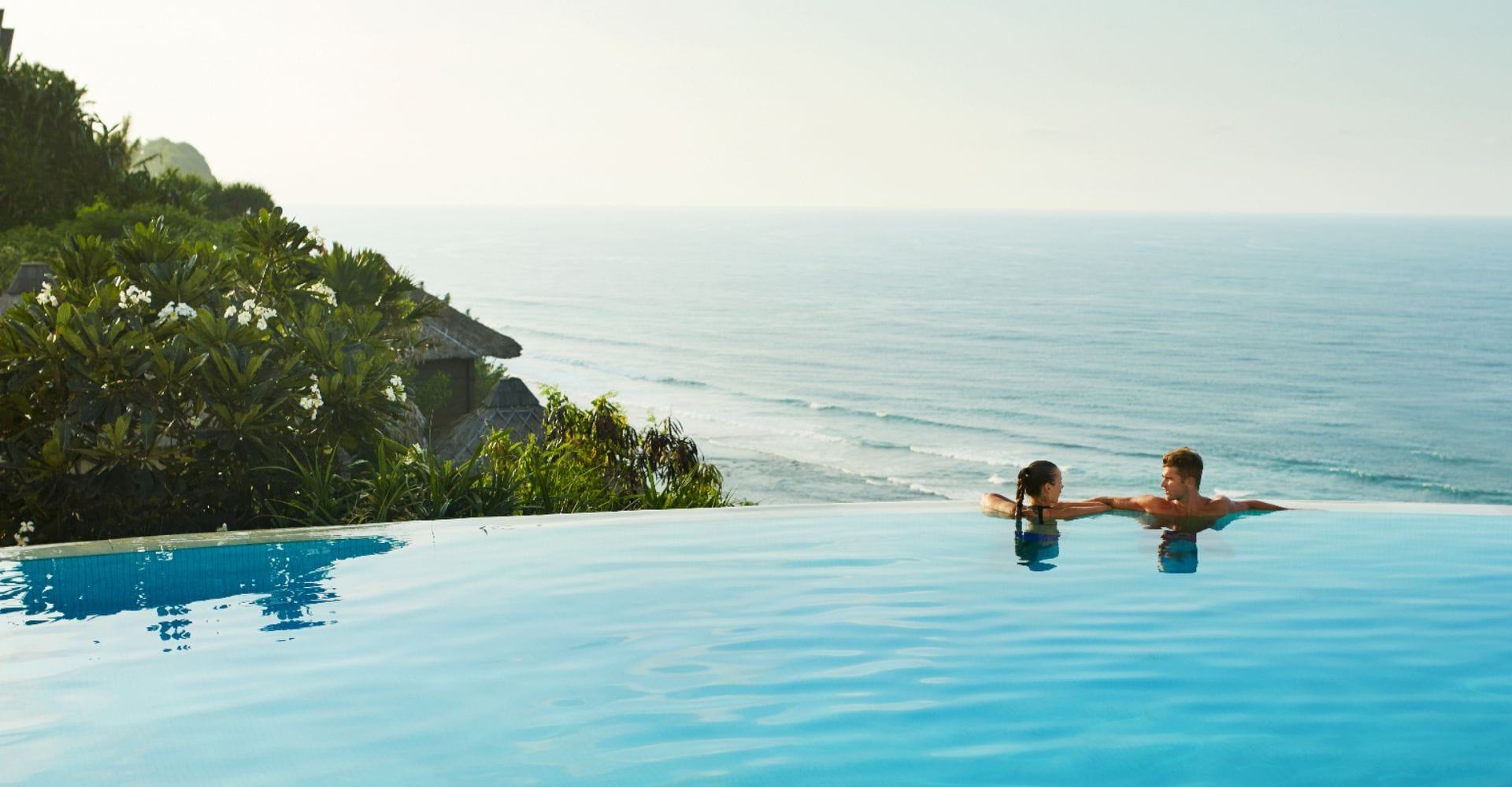 Paar im Pool mit Meerblick.