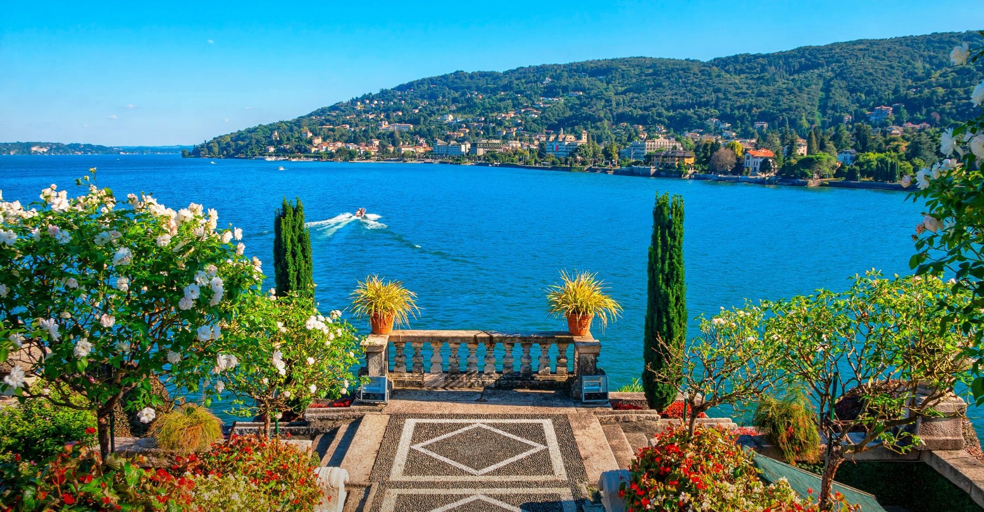 Aussicht von einer Promenade auf den Comer See mit Booten.