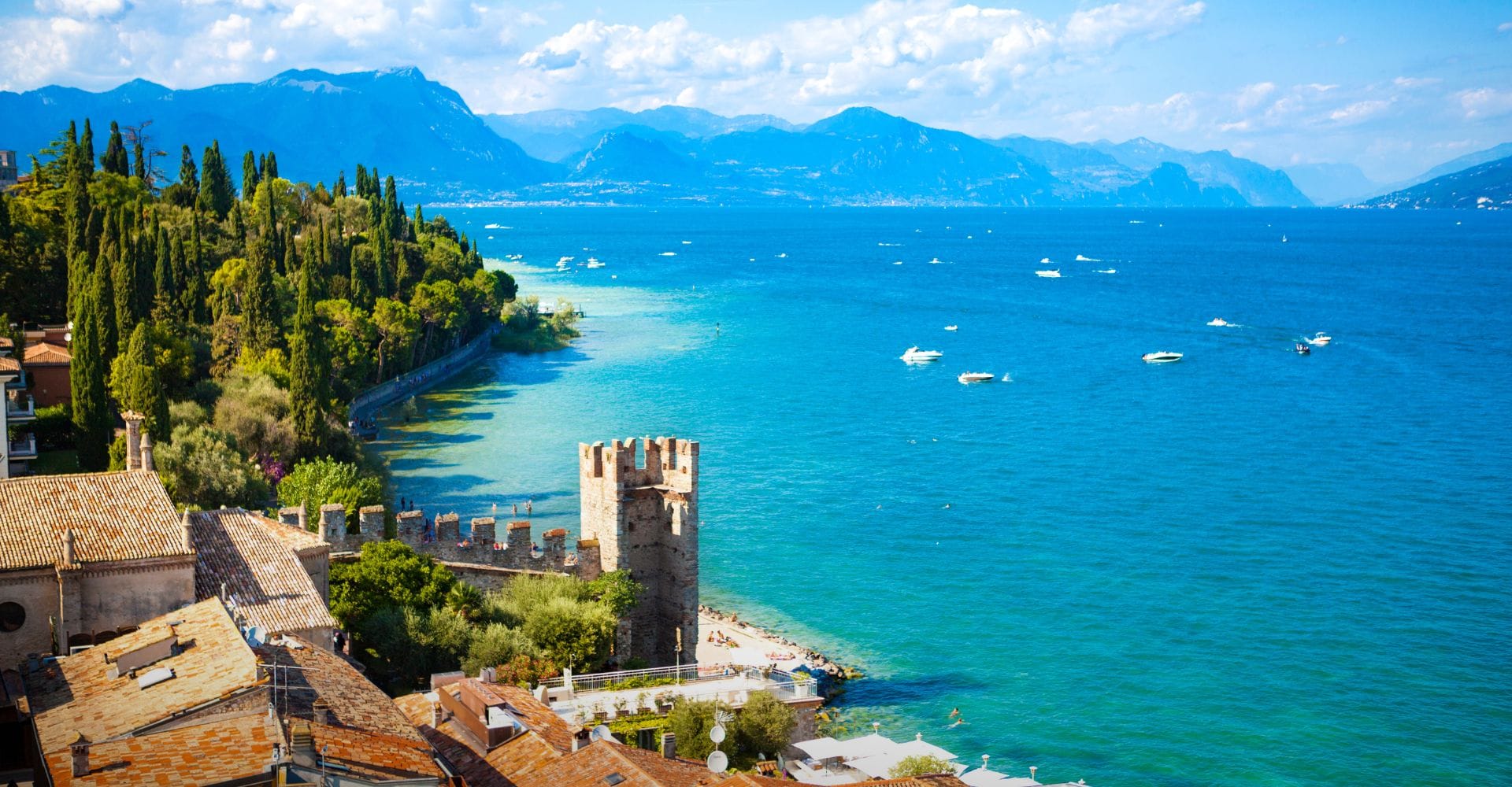 View from a boardwalk onto Lake Como with boats.